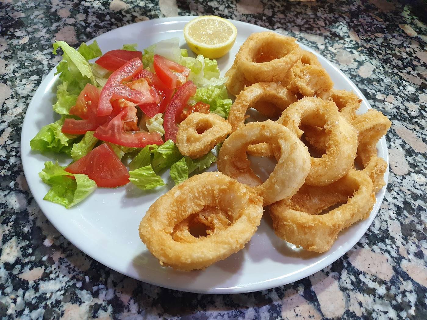 Plato de calamares a la romana con ensalada fresca